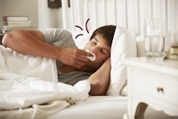 Ung mand i sengen med influenza