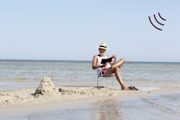 Moden mand sidder i en stol på stranden i direkte sollys uden solcreme på kroppen.